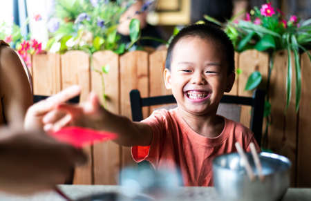 Chinese boy receiving red pocket on the dining tableの写真素材