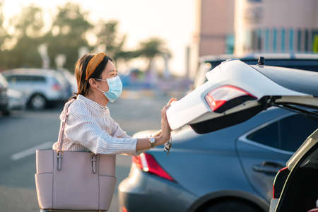 Asian girl wearing face mask at a parking lot outdoorsの写真素材