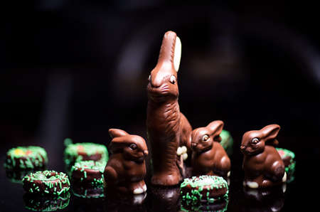 Chocolate Easter Bunny and eggs on reflective dark table
