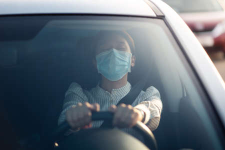 Asian girl wearing face mask in a carの写真素材
