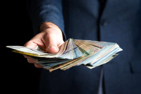 Businessman hand holding bunch of dollar billsの写真素材