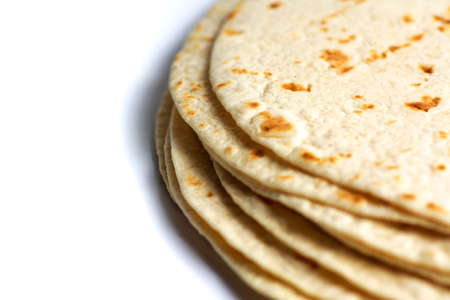 Stack of fresh corn tortillas on white