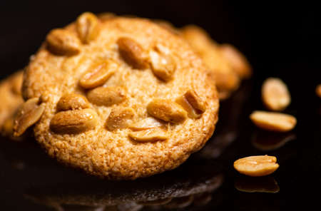 Integral cookies with peanuts on dark background closeup