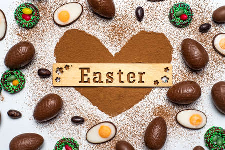 Easter cards with chocolate eggs and cacao powder flat layの写真素材
