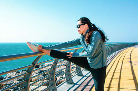Girl stretching before workout by the seaside. Active lifestyleの写真素材
