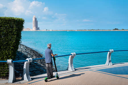Senior man using electric scooter for transportation by the seaside. Healthy outdoors senior lifestyleの写真素材