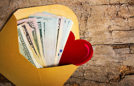 US dollar banknotes in a yellow envelope
