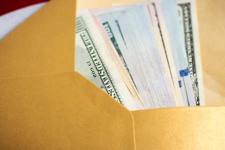 US dollar banknotes in a yellow envelopeの写真素材