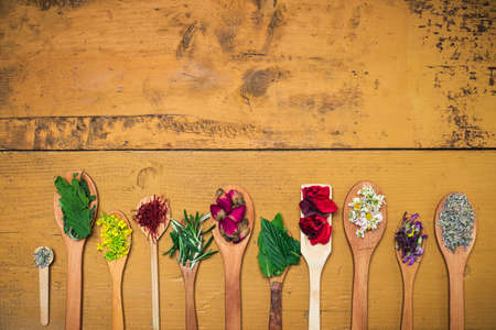 Herbal tea flowers collection on a wooden table with copy space top viewの写真素材