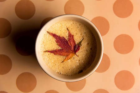 Coffee with autumn leaf on a table top viewの写真素材