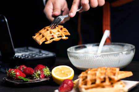 Man making waffles on a waffle machine close up