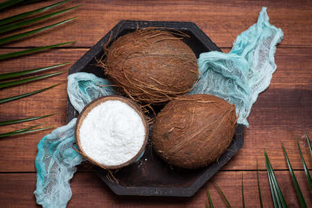 Open and grated coconut fruit on a wooden table top view
