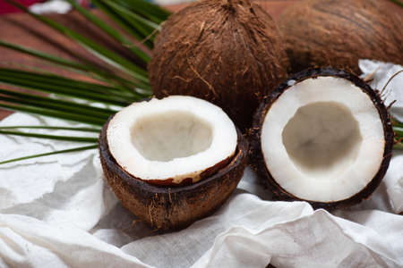 Halved open coconut fruit on a wooden table top view