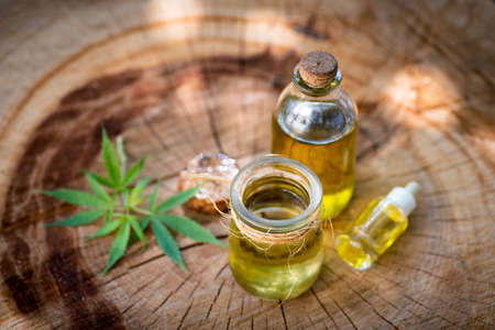 Marijuana oil in a bottle on a wooden logの写真素材
