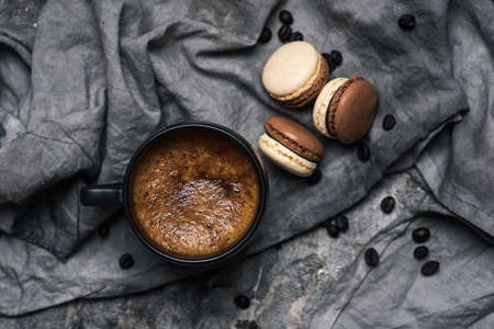 Macaron or macaroon sweet cookie desserts and a cup of coffee on a wooden table tabletop viewの写真素材
