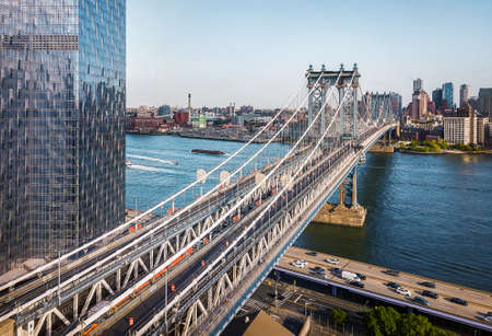Aerial view of Manhattan bridge and downtown Brooklyn above East river on a sunny bright day in New...