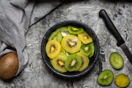 Green and yellow kiwi slices on a plate tabletop view