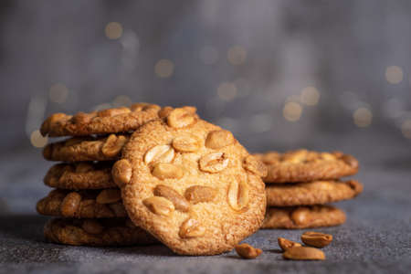 Stack of homemade biscuits with peanuts on a a pile against gray backgroundの写真素材