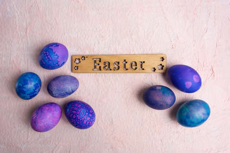 Blue purple Easter eggs with lace look and calligraphic inscription Easter on a pastel background.の写真素材