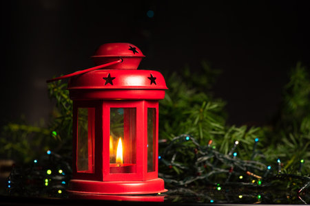 Festive winter holiday decoration and the Christmas tree with shiny fairy lights in the background