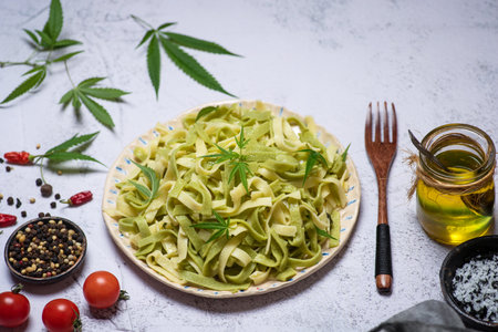 Italian traditional pasta Tagliatelle with cannabis leaves in a ceramic bowl on a white background top viewの写真素材