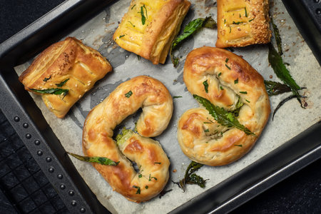 Food with cannabis. Homemade baked pie, decorated with green marijuana leaves in a baking dish on black marbleの写真素材