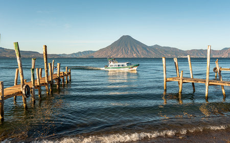 Wooden docks on Lake Atitlan on the beach in Panajachel, Guatemala. With Toliman and San Pedro volcanoes in the background. A beautiful bay of lake with a view of the volcanoes in the highlands of Guatemalaの写真素材