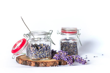 Fragrant lavender flowers in small glass jars on a white background. They can be used in aromatherapy, cosmetics, alternative medicine and nutritionの写真素材