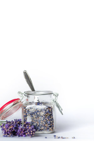 Fragrant lavender flowers in small glass jar on a white background. They can be used in aromatherapy, cosmetics, alternative medicine and nutritionの写真素材