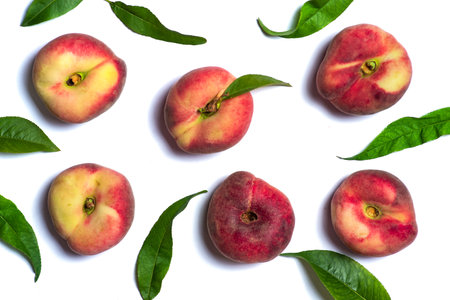 Ripe, juicy peaches with green leaves on a white background. Fresh, organic vegan foodの写真素材