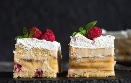 Homemade cake with fresh bananas, raspberries, vanilla cream, soft crust and white whipped cream. Delicious, creamy, refreshing sweetの写真素材