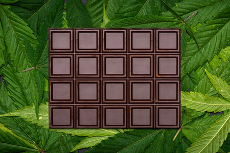 Chocolate bars on top of marijuana background top view