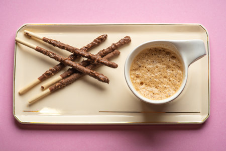 A beautiful arrangement of chocolate-dipped sticks paired with coffee, presenting a cozy and...