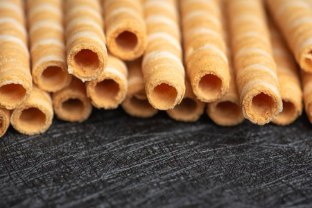A close-up view of crunchy wafer rolls showcasing the delicate texture and spiral design, inviting...
