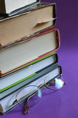 stack of books with reading glasses in frontの写真素材