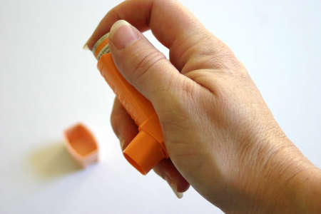 Hand holding asthmatic inhaler / pufferの写真素材