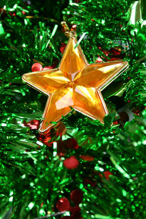 Christmas star ornament against green tinsel