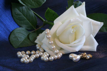 White roses and pearls against blue backgroundの写真素材