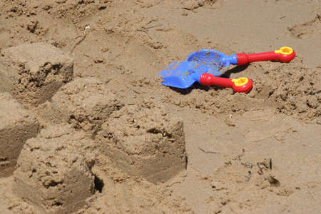 Colorful plastic spades in sand on beach