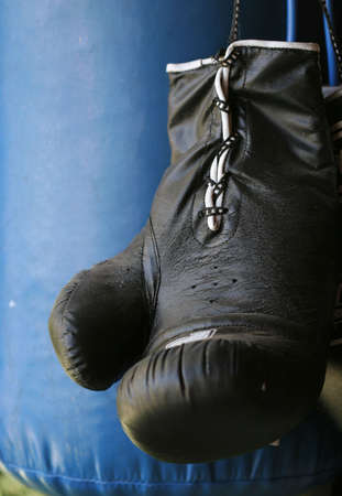 Close up of black boxing glove against blue punching bagの写真素材