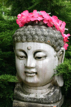 Close up of buddha head statue with floral garlandの写真素材