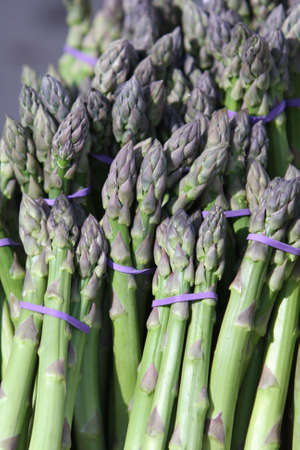 bunches of fresh organic asparagus at marketの写真素材