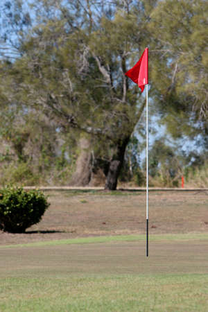 golf green red hole marker flag on golf courseの写真素材