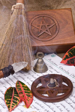 wooden pentacle with incense burning with hand written book of shadows and fall leaves - autumn equinox mabon ritualの写真素材