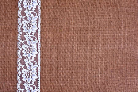 background - brown color burlap hessian with white lace borderの写真素材