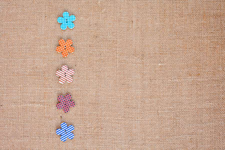 background - natural color burlap hessian with flower buttonsの写真素材