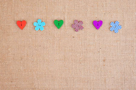 background - natural color burlap hessian with flower and heart shape buttonsの写真素材