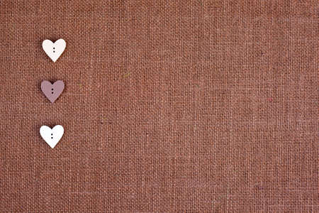 background - brown color burlap hessian with heart shape buttonsの写真素材