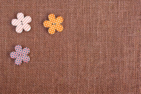 background - brown color burlap hessian with flower shape buttonsの写真素材