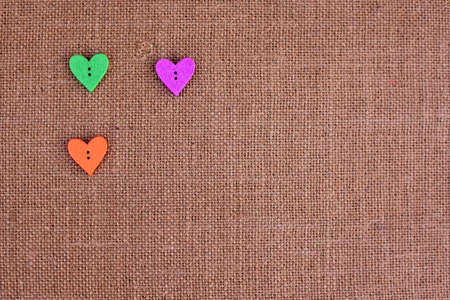 background - brown color burlap hessian with heart shape buttonsの写真素材